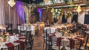 Elegant wedding reception setup at Chandelier Event Venue with floral centerpieces, crystal chandeliers, and candlelit tables.