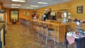 Interior tasting room at Hinnant Family Vineyards with wooden bar, stools, and wine displays.