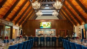 Elegant tasting room at JOLO Winery and Vineyards with chandeliers, wood-beamed ceilings, and a wine bar setup.