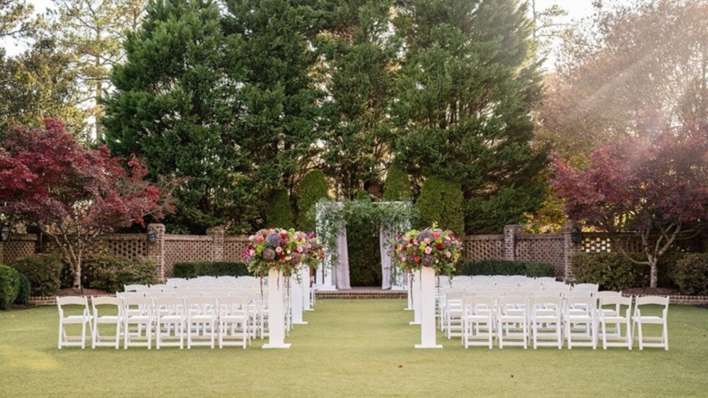 Outdoor wedding ceremony setup at The Sutherland with white chairs, floral arrangements, and a garden backdrop.